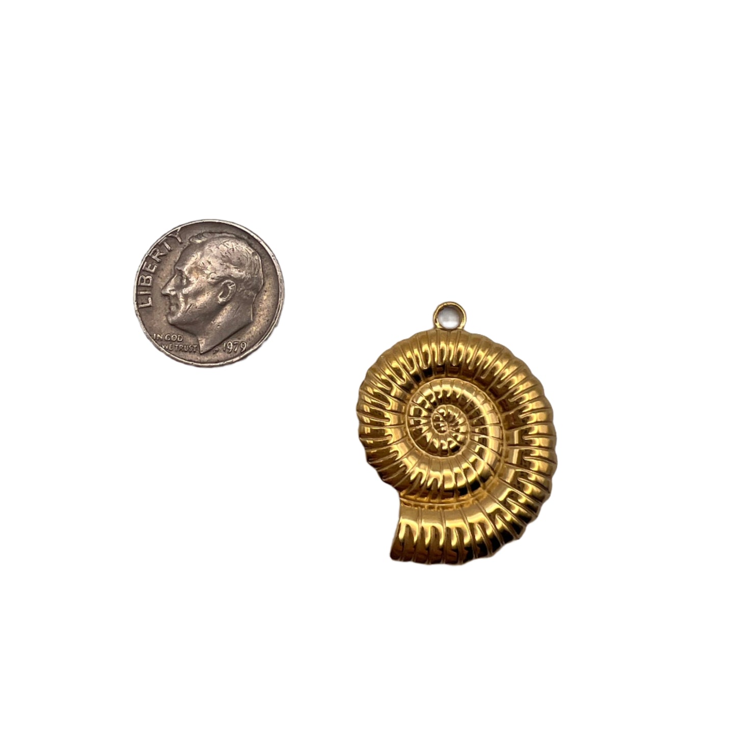 Gold spiral pendant next to a silver coin on a white background