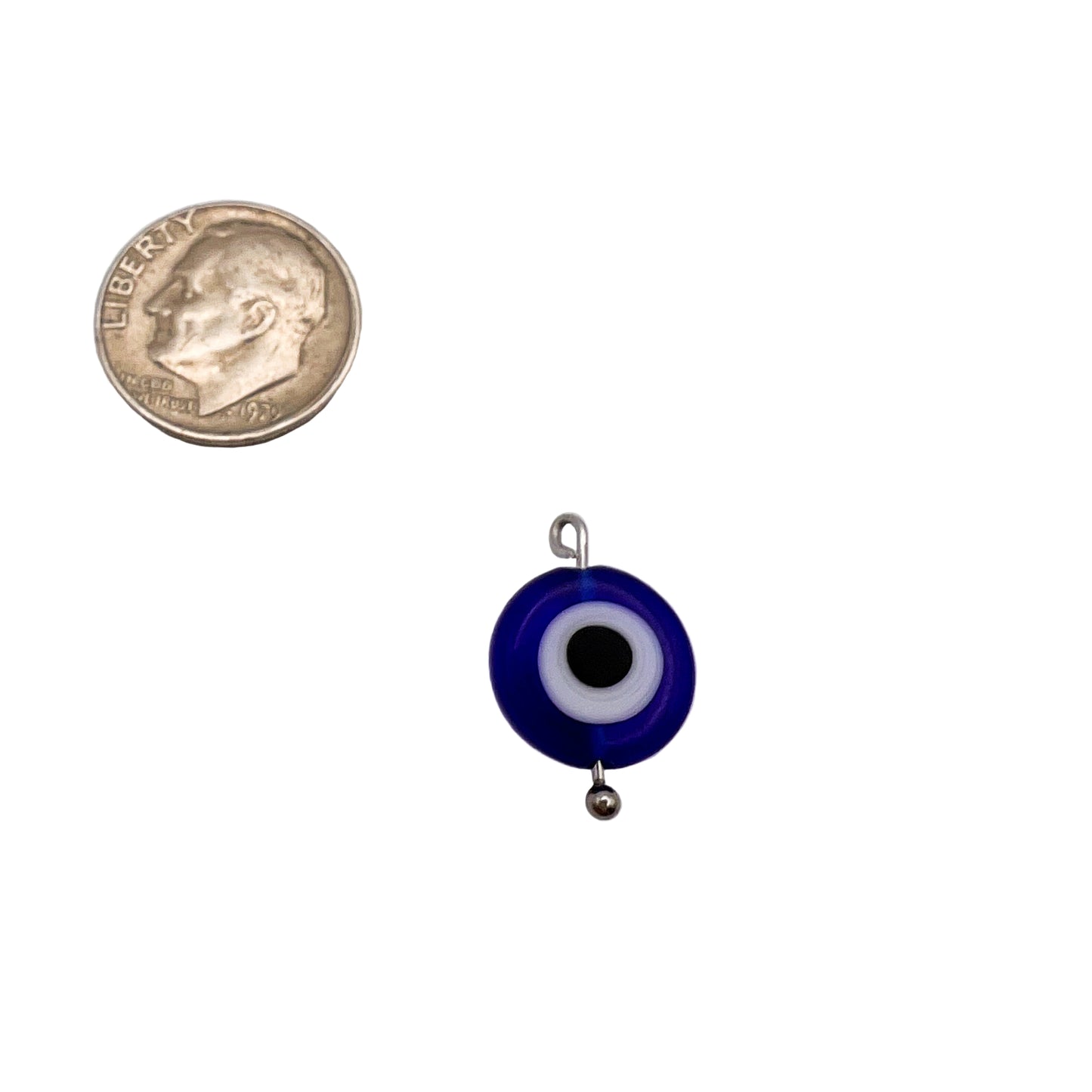 Small blue evil eye pendant with a coin for scale on a white background