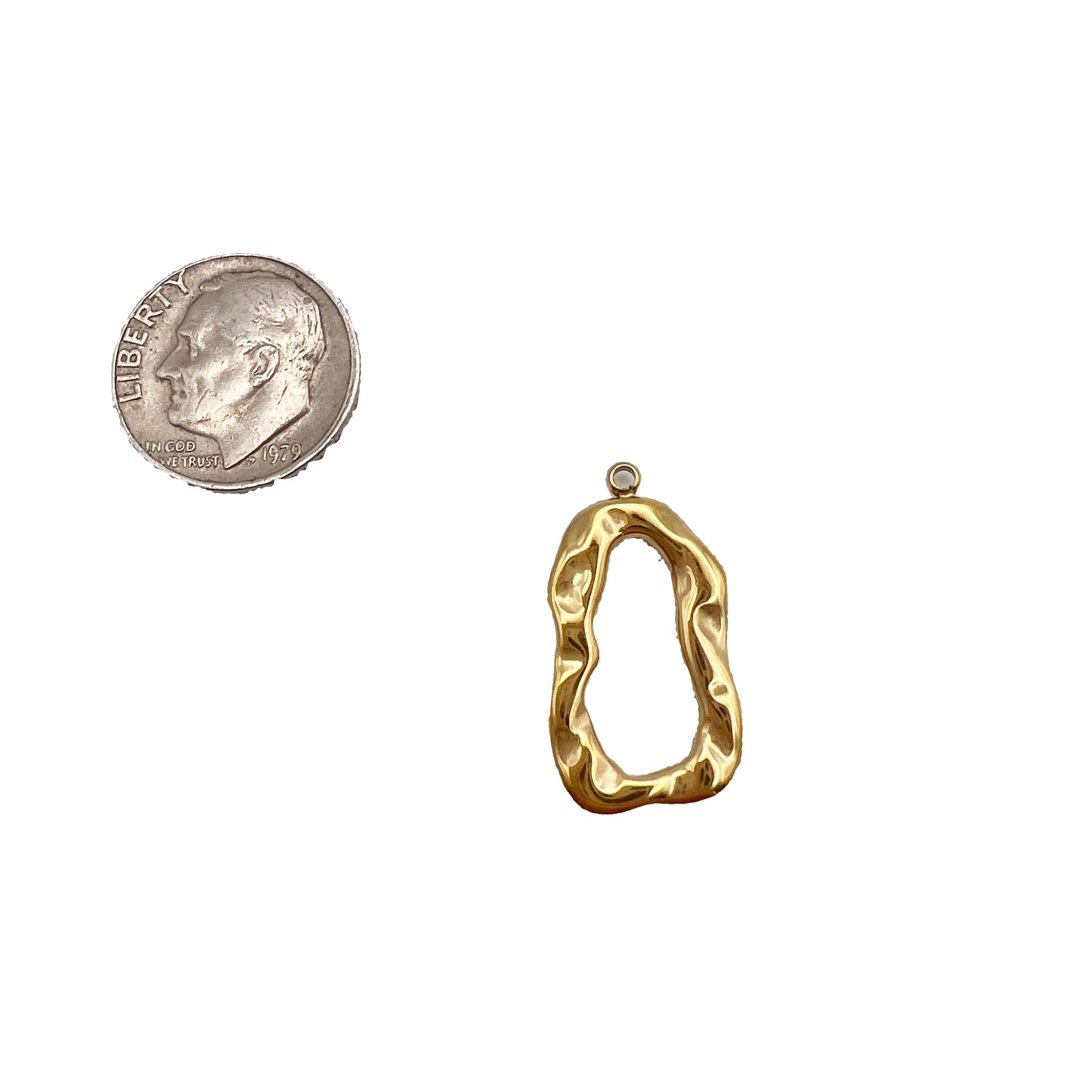 Gold pendant next to a quarter on a white background