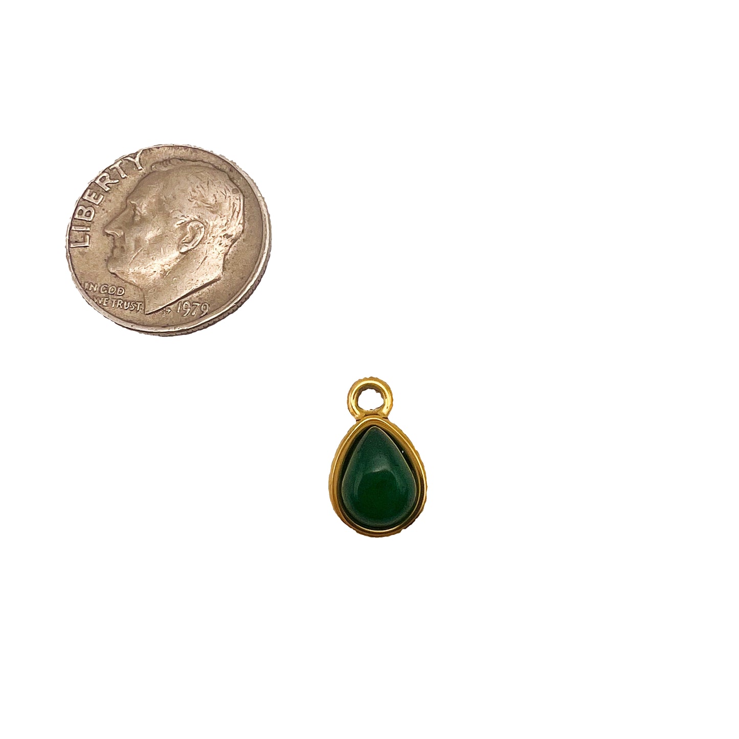 Gold pendant with green teardrop stone next to a quarter on a white background