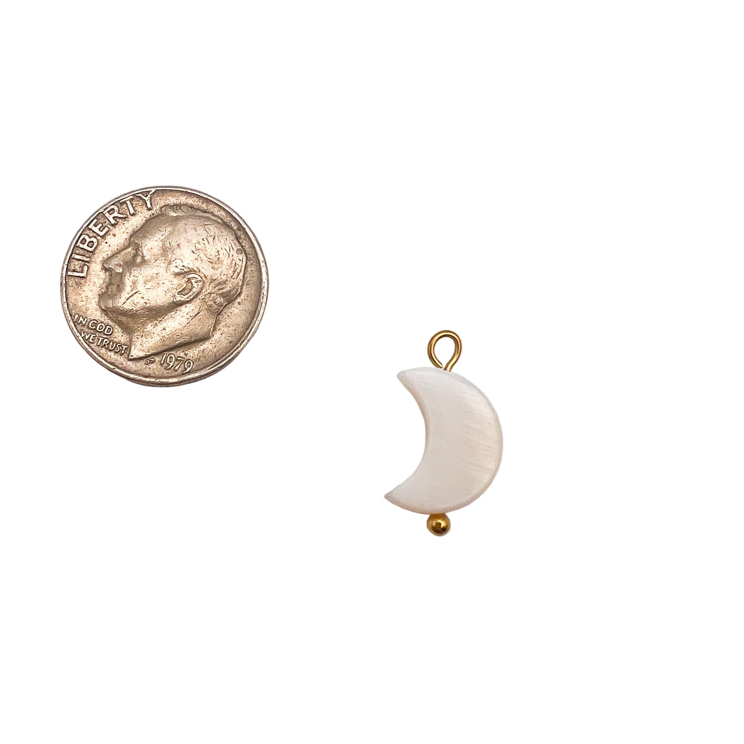 Small moon-shaped pendant with gold accent next to a quarter on a white background