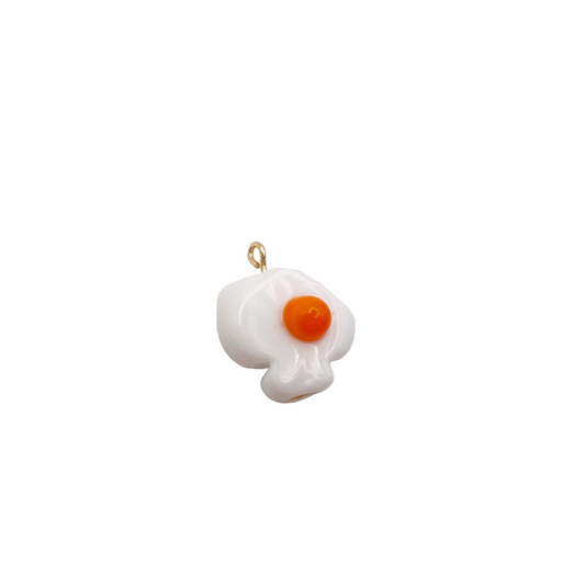 Pendant shaped like a fried egg on a white background