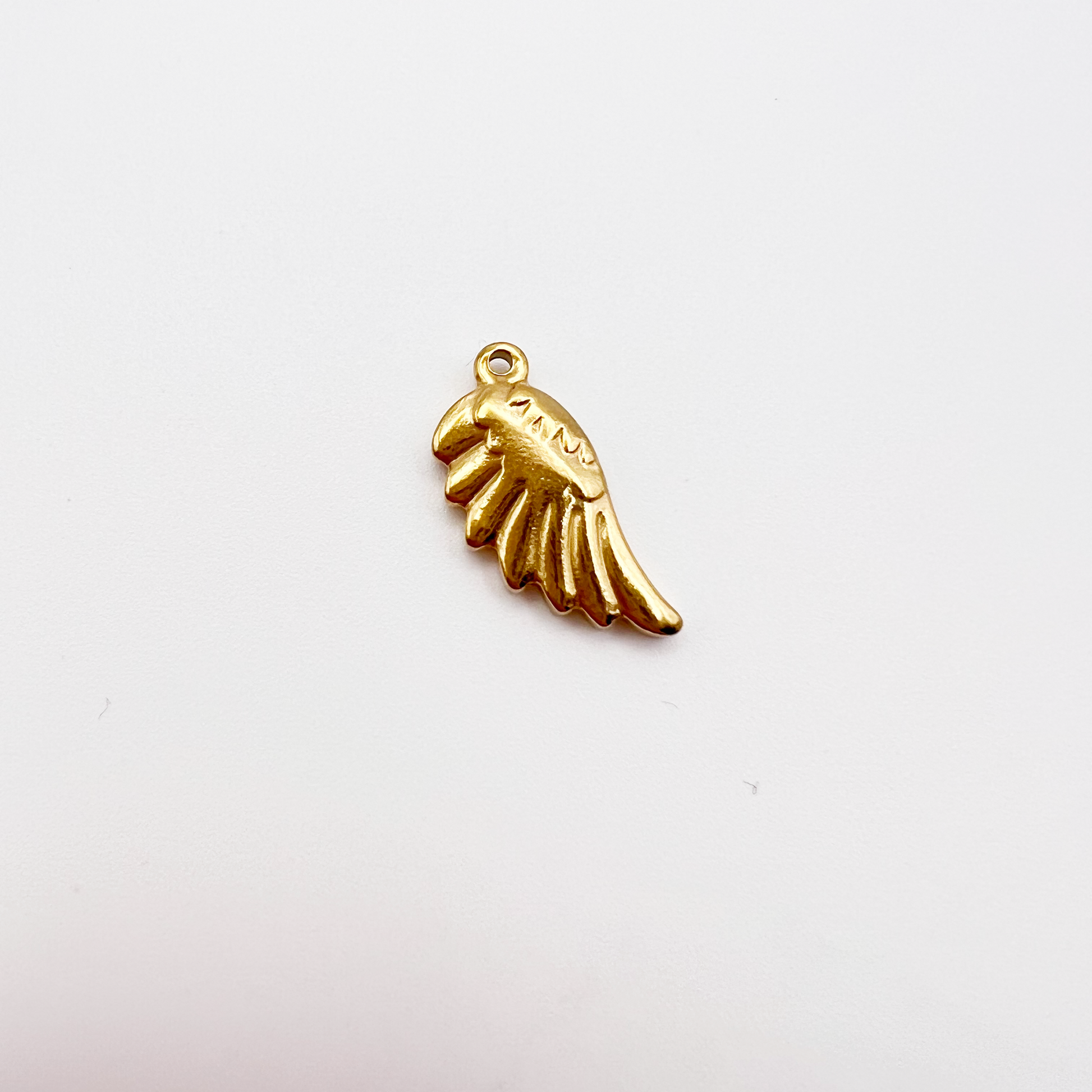 Gold wing-shaped pendant on a light gray background