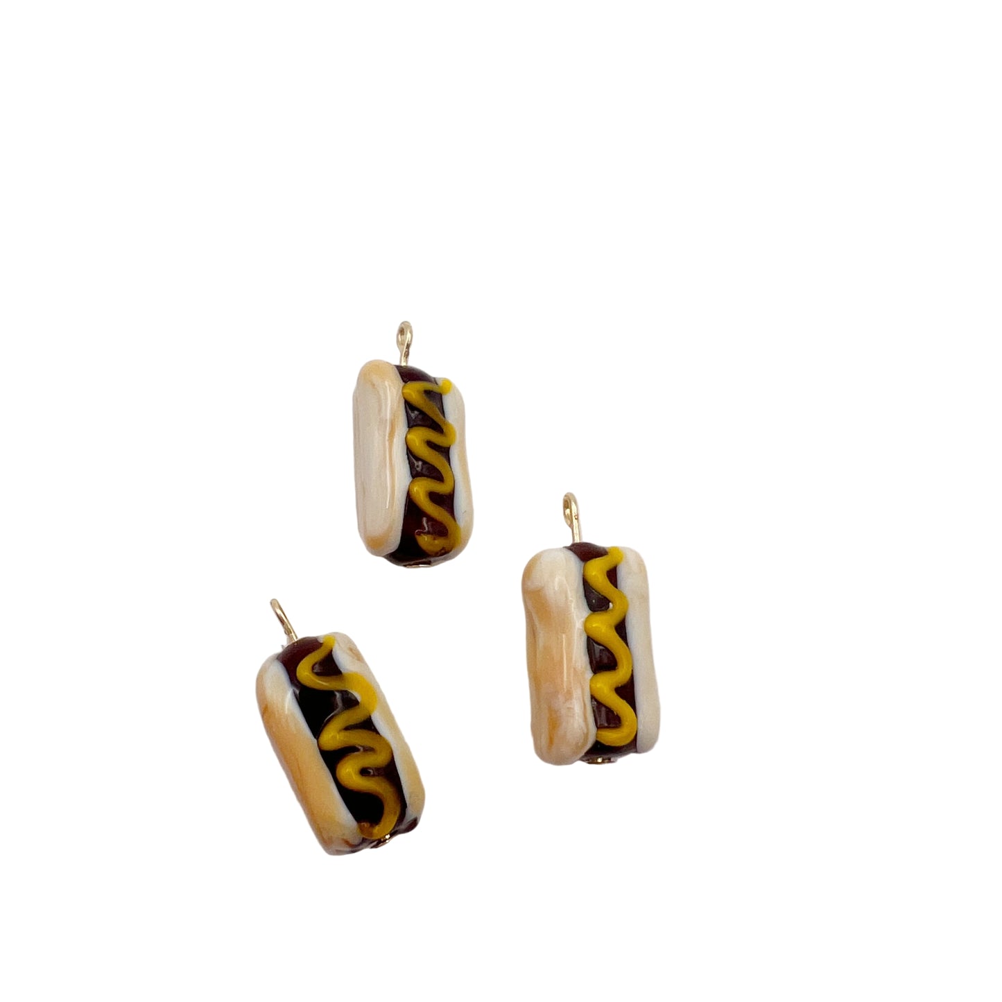 Hot dog-shaped earrings with mustard and ketchup on a light gray background