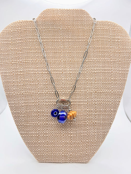 Necklace with blue and gold beads on a beige display stand