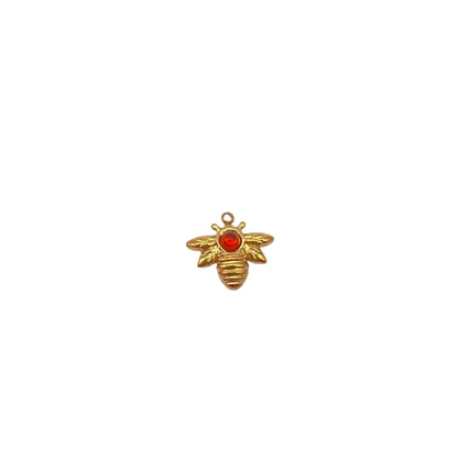 Gold bee-shaped pendant with a red gem on a white background