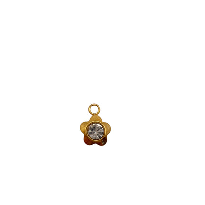 Gold charm with a clear gemstone on a white background