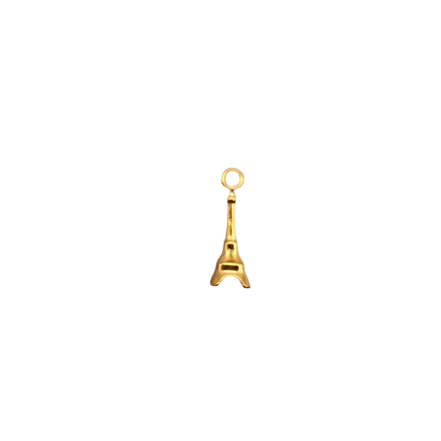 Gold eiffel tower charm on a light gray background