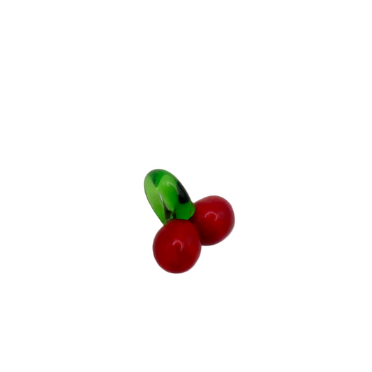 Small glass bead shaped like a cherry on a white background