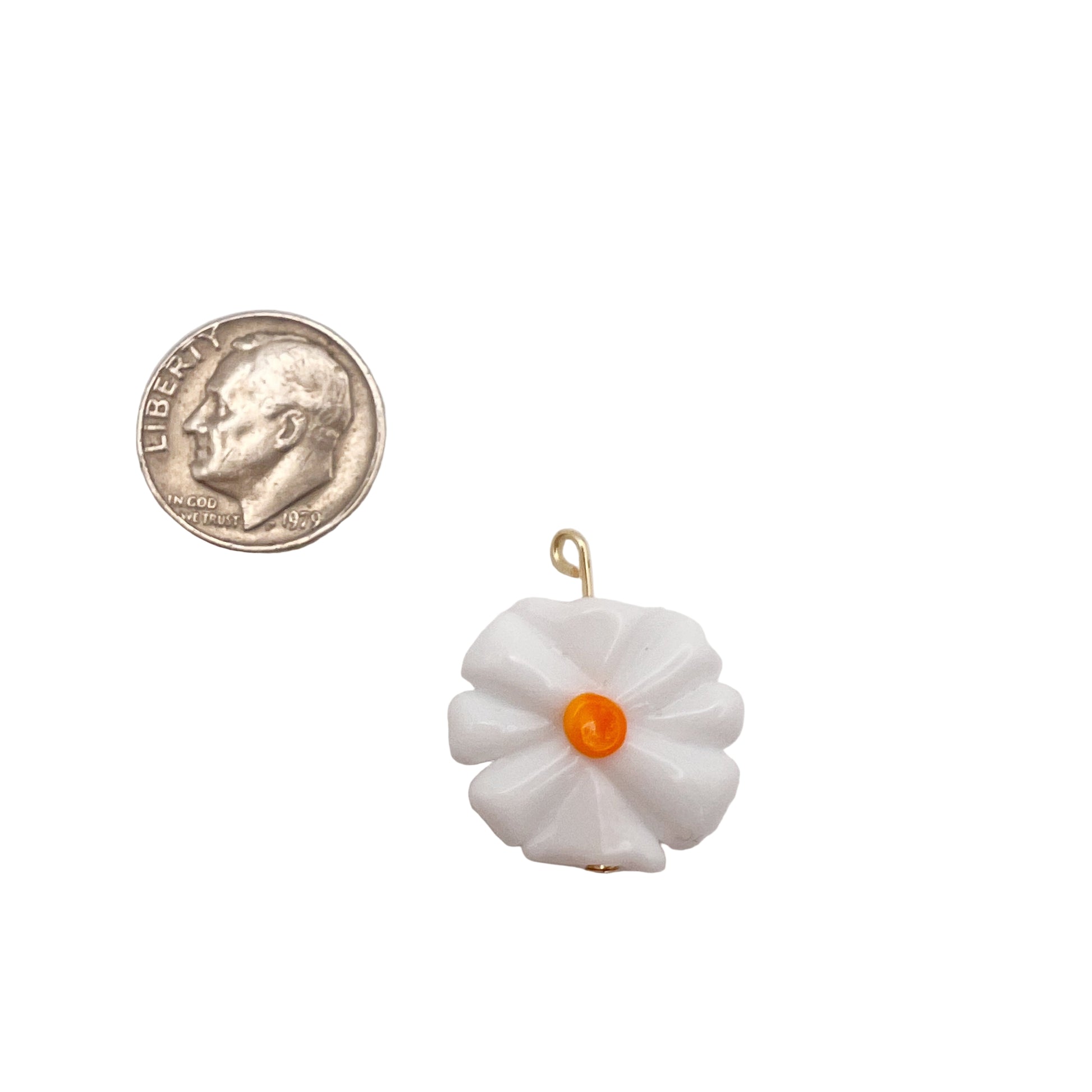 White flower-shaped pendant with an orange center next to a quarter on a light gray background