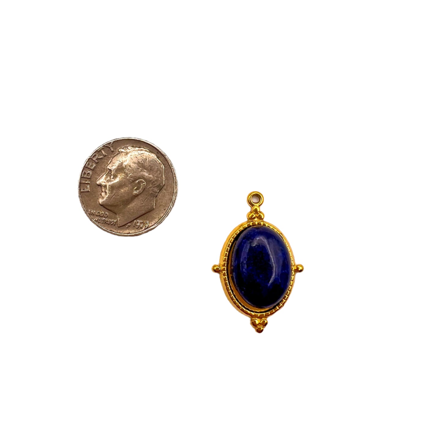 Gold pendant with a blue stone next to a U.S. quarter on a white background