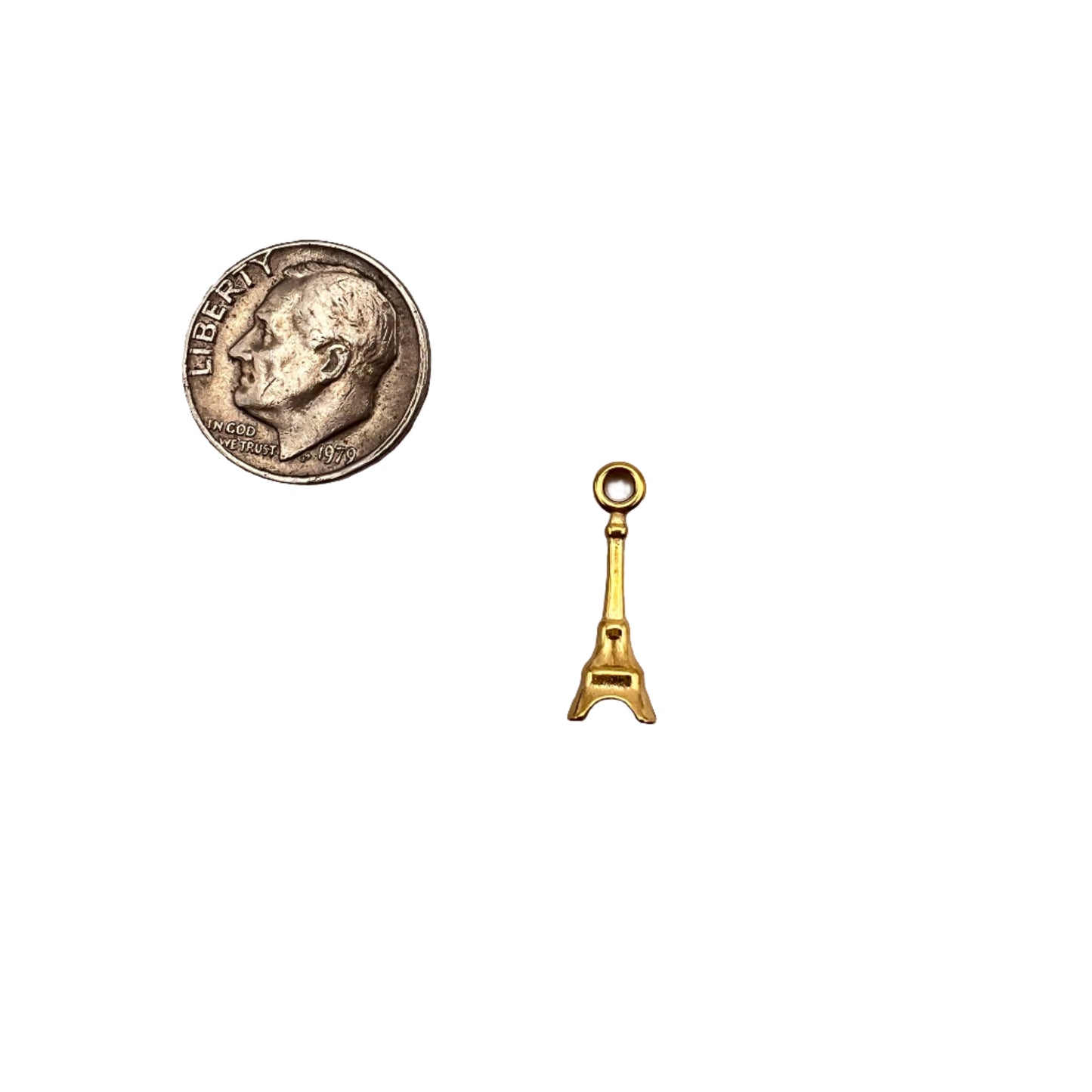 Small gold key-shaped object and silver coin on a light gray background