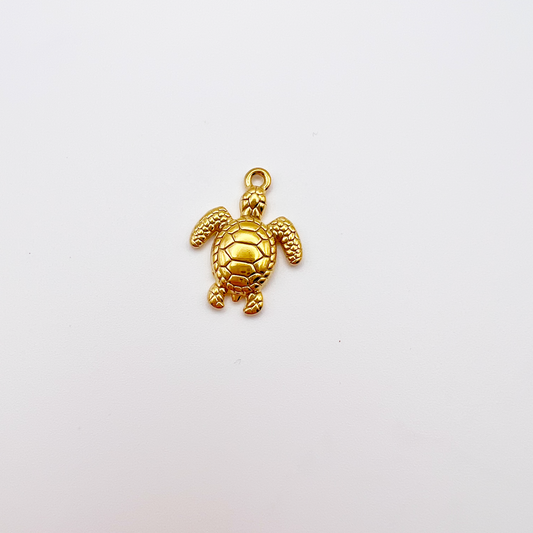Gold turtle charm on a light gray background