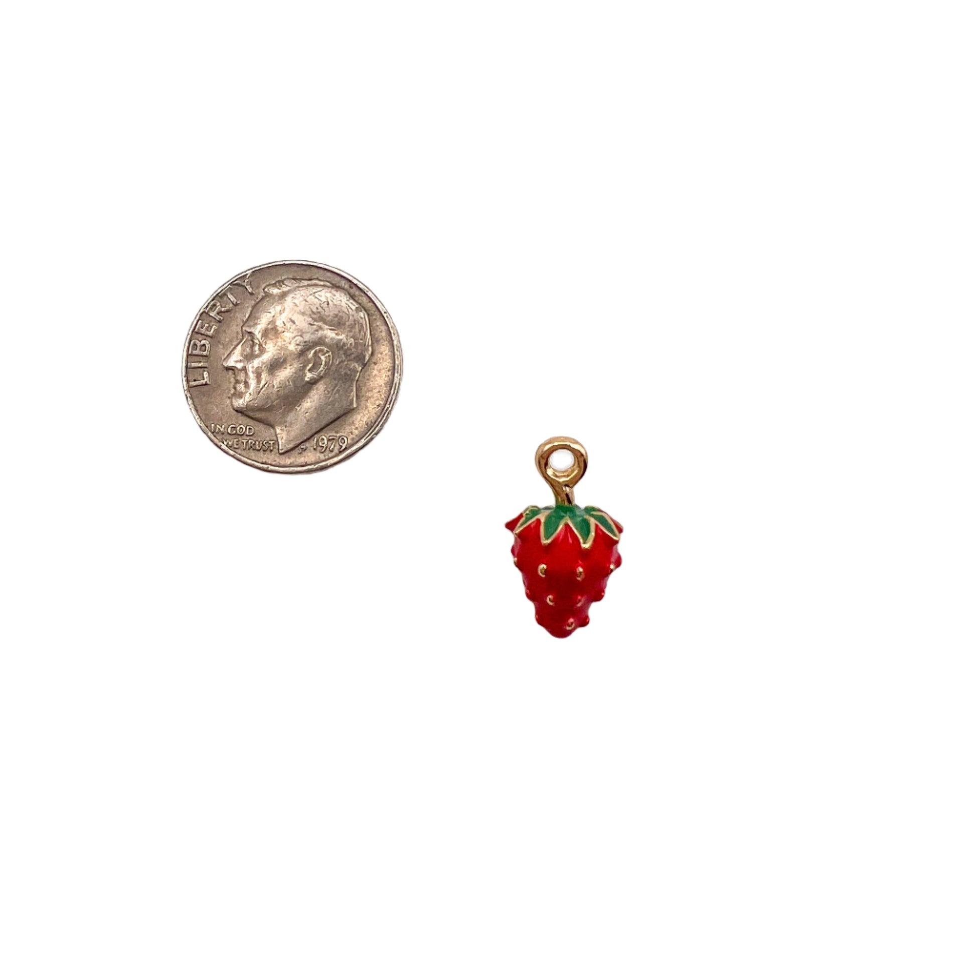 Red strawberry charm next to a dime on a white background