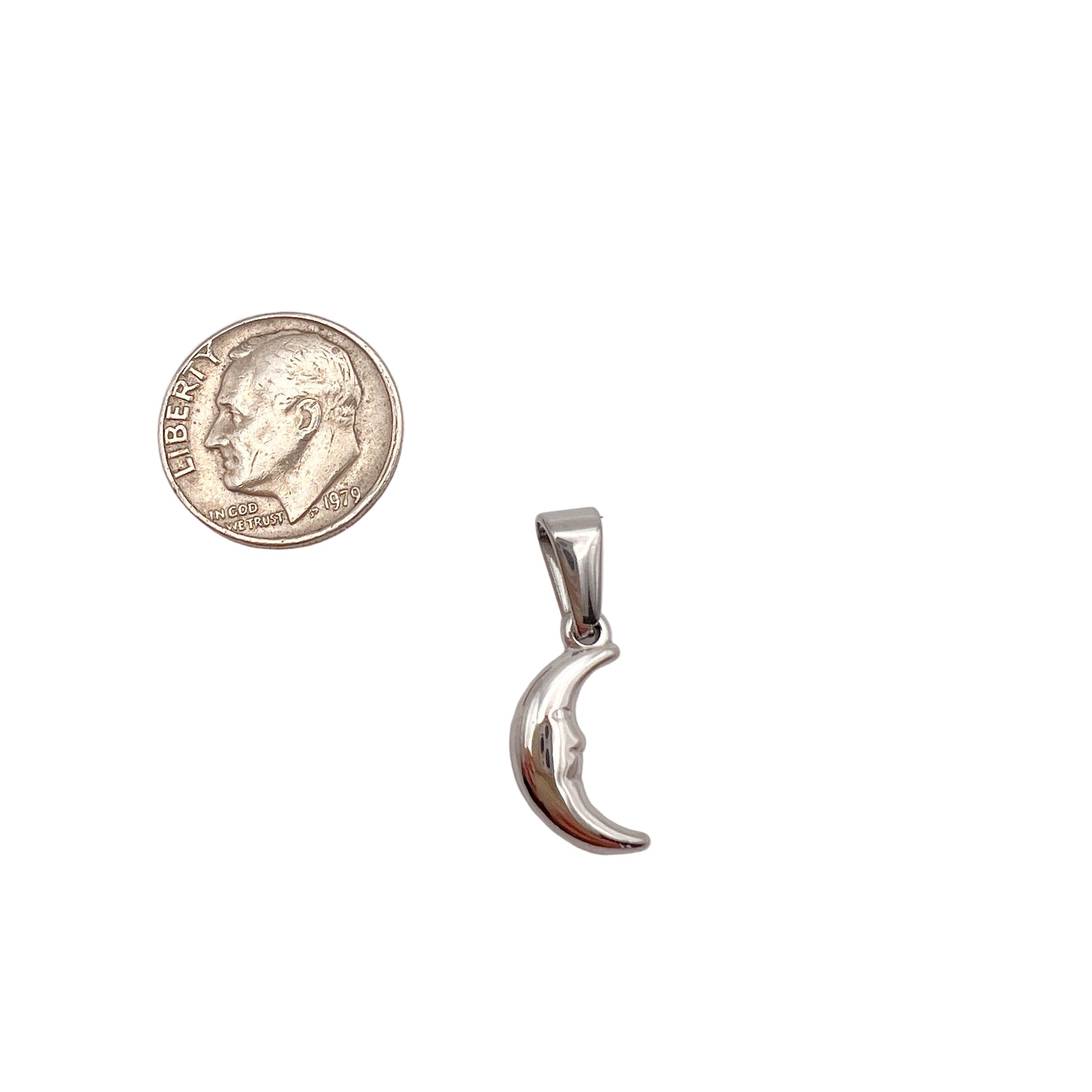 Silver crescent moon pendant next to a quarter on a white background