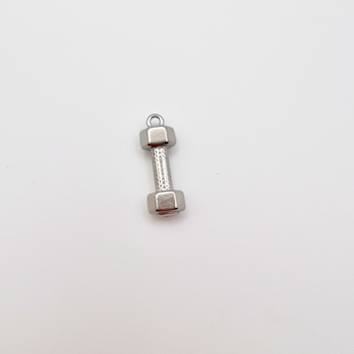 Silver dumbbell-shaped charm on a light gray background
