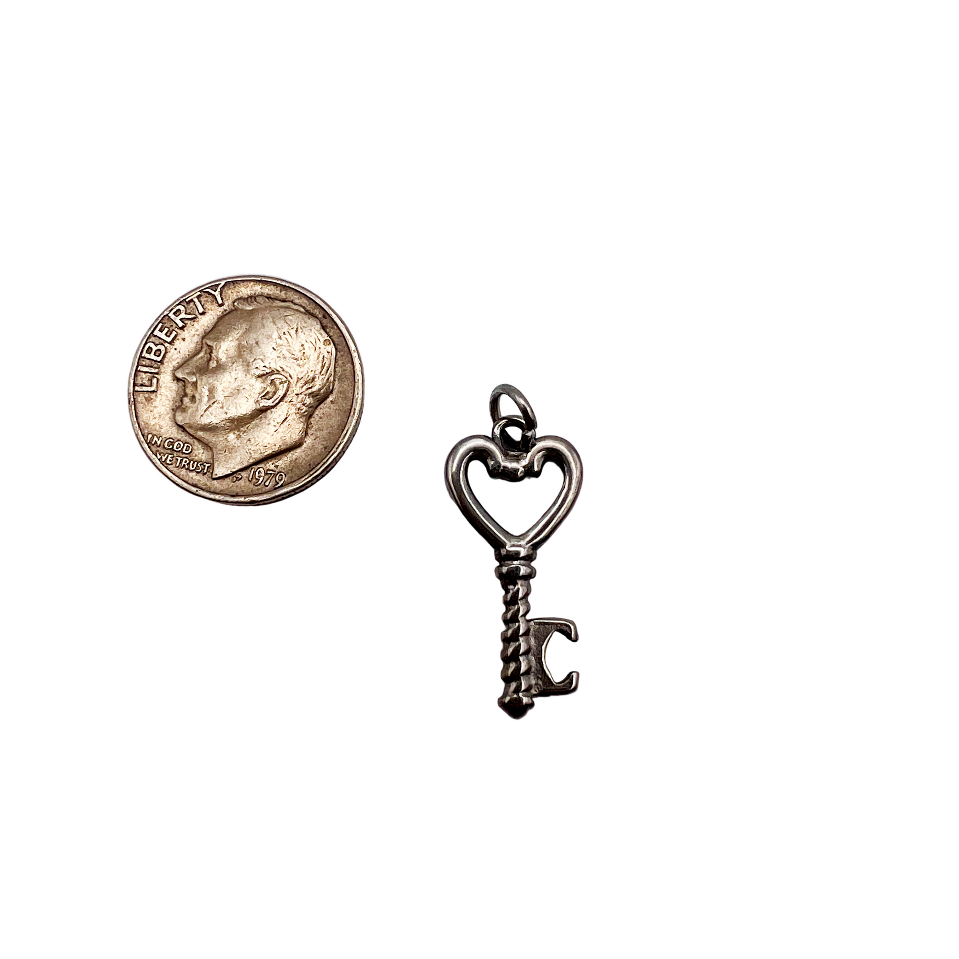 Key-shaped bottle opener with a coin on a light gray background