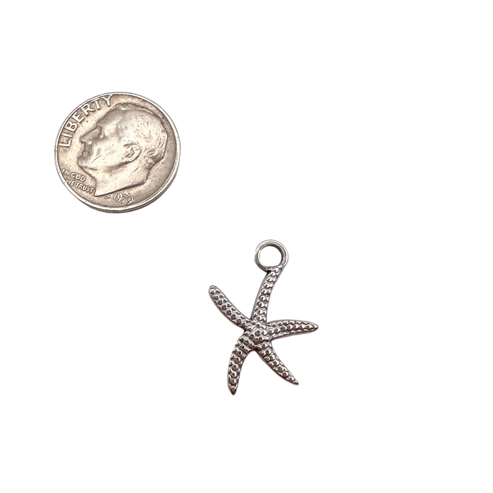 Silver starfish pendant next to a U.S. quarter on a white background