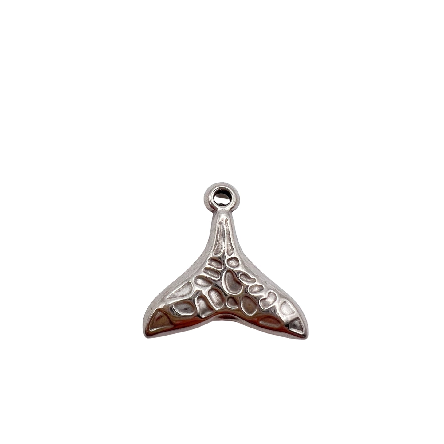 Silver whale tail charm on a white background