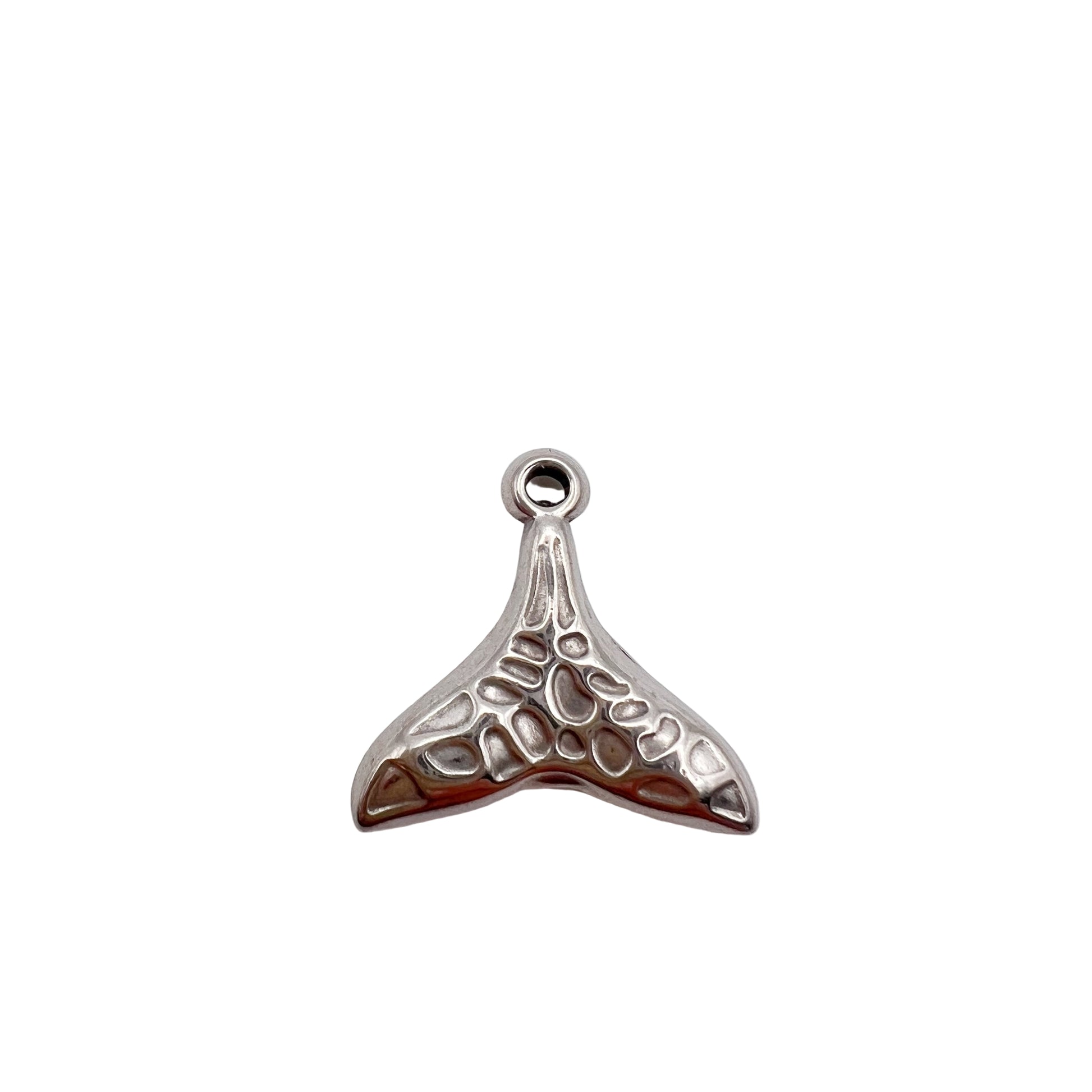 Silver whale tail charm on a white background